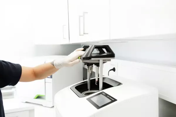 Eine Zahnärztin reicht einer Patientin einen Handspiegel. Im Spiegelbild sieht man das Lächeln der Patientin, während sie ihre Zähne betrachtet.